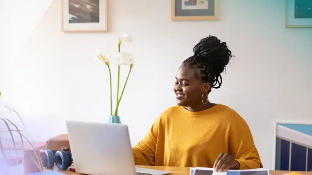 Black Entrepreneur woman in front of a computer smiling.